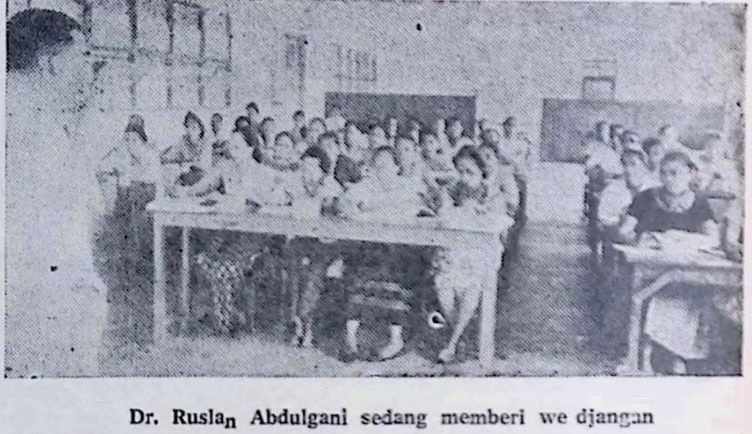 Foto hitam putih Dr. Ruslan Abdulgani sedang memberikan wejangan atau ceramah kepada sekumpulan perempuan yang duduk di dalam kelas (ardiholmes.id).