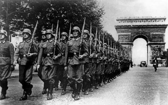 Pasukan Jerman berbaris di Champs-Élysées dengan Arc de Triomphe di latar belakang, Paris, 1940